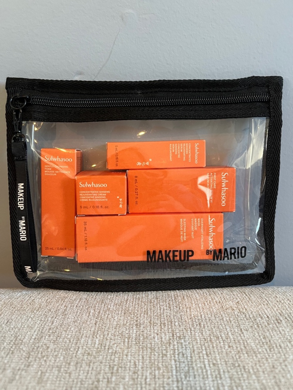 Makeup by Mario Clear Cosmetic Pouch with Orange boxes filled with Skincare